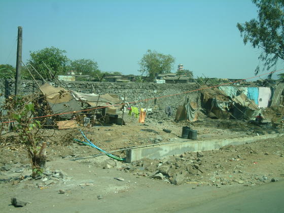 Primitive shelters by the side of a dusty road
